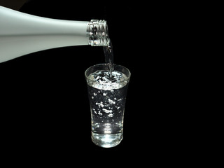 Tokyo,Japan-May 6, 2020: Pouring sake, liquor made from rice, from sake bottle into a shot glass on black background
