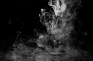 White puffs of smoke on a black background float mixing in bizarre chaotic patterns of thin threads