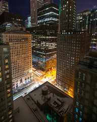 Downtown Chicago at night with busy streets and tall skyscraper buildings