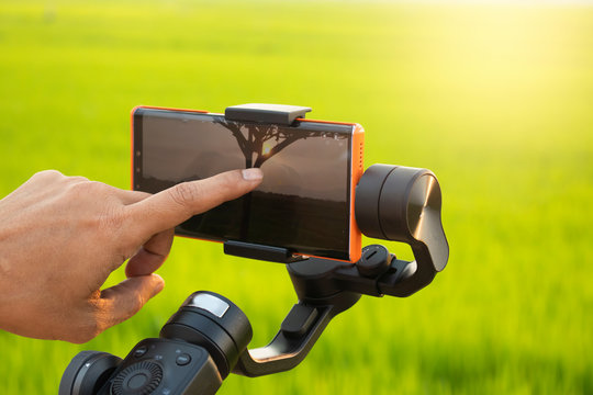 Male Hand Touching Smartphone Attached To A Gimbal