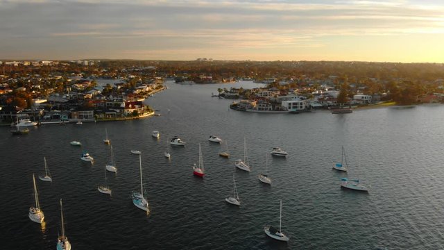 Aerial Circles Moored Boats in Bay During Golden Sunset. Wide Shot