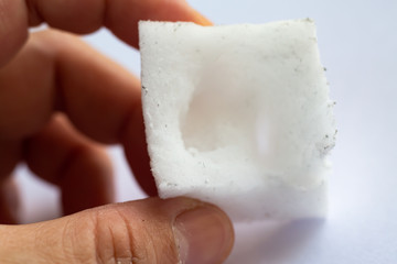 Woman left hand using Melamine sponge or Magic nano sponge on white background, Close up shot, Selective focus, Housekeeping clean concept