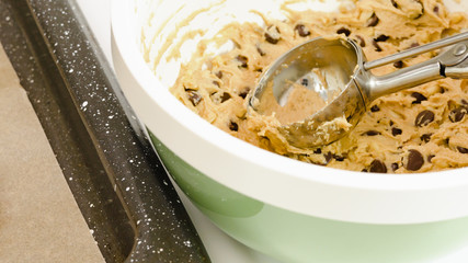 Chocolate Chip Cookie batter close up in a bowl on white kitchen table.
