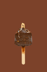 mostly eaten chocolate outer popsicle with blueberry sauce inside on brown background