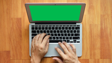 Man hands working on the laptop and touch pad, isolated on green screen.