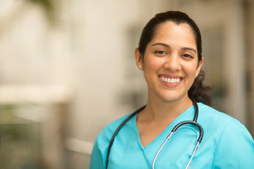 Happy Hispanic medial provider at work stock photo.
