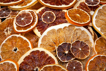 Dried slices of various citrus fruits on dark blue background