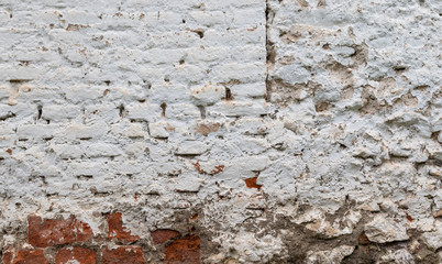 Stone and brick wall covered with lime. Old and rustic texture.