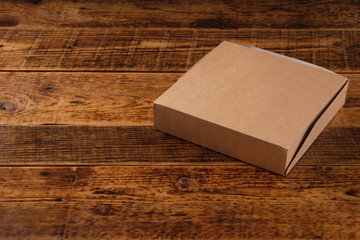 Big brown paper box isolated on wooden background. Eco-friendly disposable food packaging. Preserving nature and recycling concept.Copy space.