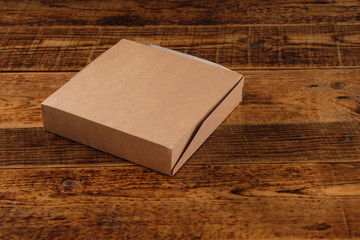 Big brown paper box isolated on wooden background. Eco-friendly disposable food packaging. Preserving nature and recycling concept.Copy space.