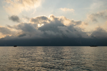 Morning mist Is covering a large mountain In the lake And there are 2 tour boats floating in the lake. , Khao Sok National Park ,Thailand
