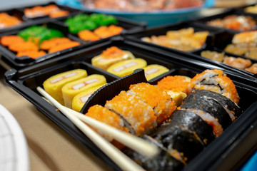 Japanese food , Sushi rolls are arranged in sets in a black tableware container