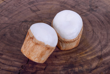 Young coconut peeled on a wooden background