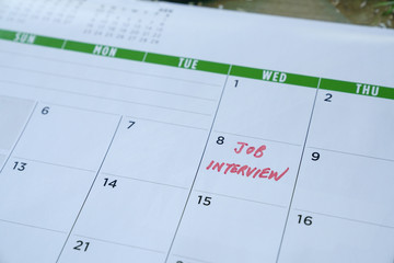 Job interview words written on table calendar with red marker