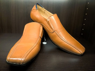 Men leather shoes on the shelf in the store. Brown men's shoes on the stand. Male style, fashion. Gathering the groom. 