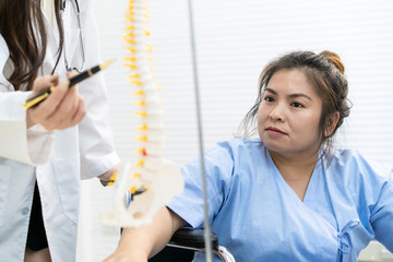 Asian fat woman patient talking with specialist doctor in hospital about her health disease. Woman worry about the critical problem at her backbone. Overweight may cause of physical injury.