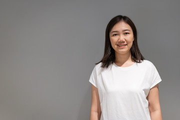 Beautiful young Asian ethnicity woman portrait on the grey concept wall with copy space close up.
