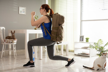 Fototapeta na wymiar girl in isolation doing leg exercise with briefcase accompanied by pets