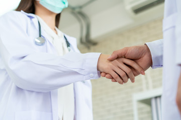 Two senior specialist doctor making a handshake together, trust and good teamwork in medical service in hospital. Concept of collaborative medical partnership in medical service and enterprise.