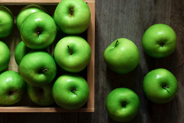 Green apples in a basket on a wooden background
