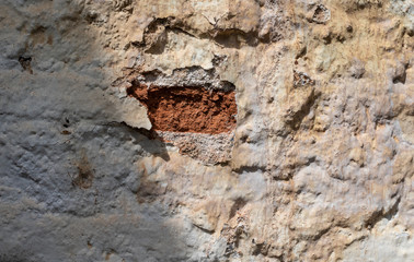 Stone and brick wall covered with lime. Old and rustic texture.