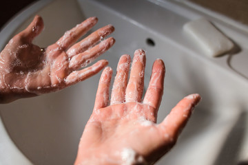 A woman washes her hands with soap.