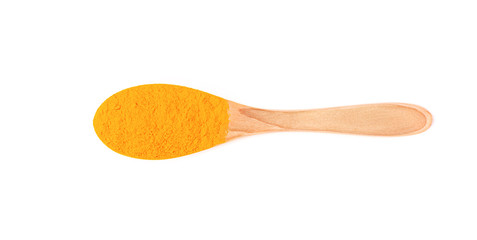 Top view isolated wooden spoon with turmeric powder.