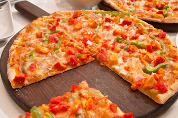 A chicken pizza served on a table ready to eat