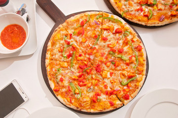 A chicken pizza served on a table ready to eat