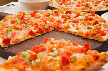 A chicken pizza served on a table ready to eat