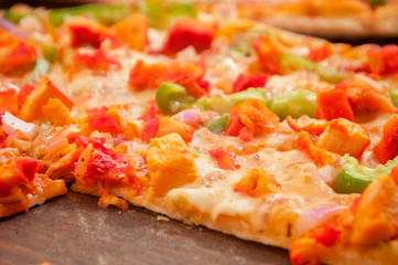A chicken pizza served on a table ready to eat