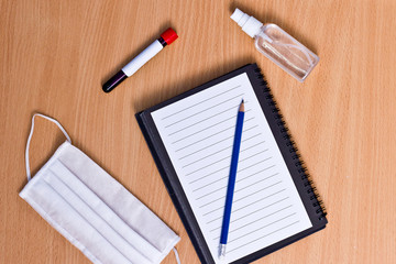 Notebook with vacuum tubes for blood collection and rubber gloves on a wooden table