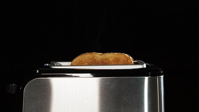 Video of a steel toaster making hot toast for breakfast.