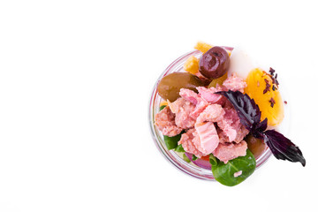Nicoise salad with tuna, vegetables, olives and capers in a glass jar on a white background