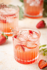 Refreshing summer drink with strawberry slices in glasses on white background