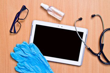 Tablet with rubber gloves test tubes and face mask top view. The concept of medicine, laboratory,...