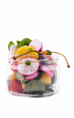 Salad with red fish, fresh vegetables - cucumber and radish, capers, egg, herbs, olives in a glass jar. The object is isolated on a white background.