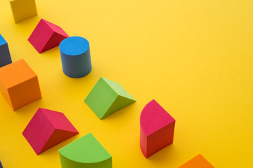 Obraz premium Set of colorful geometric cube or block toy on yellow background with copy space. Abstract pattern design composition by shape and form. Education, business solution and creative design product.