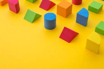 Set of colorful geometric cube or block toy on yellow background with copy space. Abstract pattern...