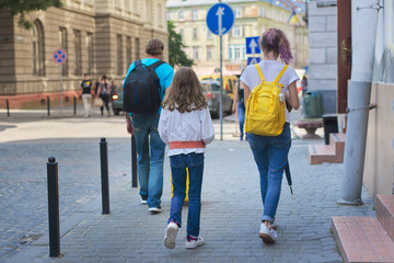 Children two girls daughters and father, tourists walking with backpacks and suitcase