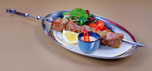 Georgian kebab of pig meat with vegetables and garlic sauce