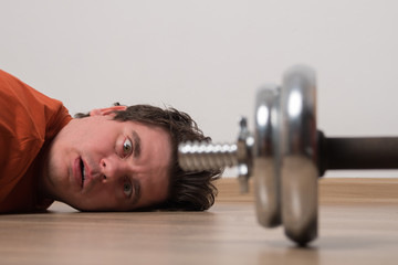 Young man goes in for sports at home. Sports activities at home. Tired of playing sports man.