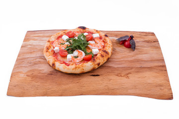 Pizza with prawns, tomatoes, arugula and cheese on a wooden tray. The object is isolated on a white background.