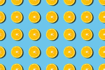 Colourful fruit seamless pattern of orange halves on blue background. Top view