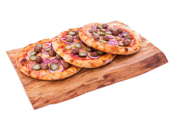 Tasty pizza with meat balls, onions, pickled cucumber on a wooden tray. The object is isolated on a white background.