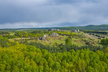 Aerial view of limestone rock formations in green located near Krakow in Poland. Shots from the drone showing the vast green hilly areas of the Cracow-Częstochowa highlands. Kraków-Częstochowa Jura.