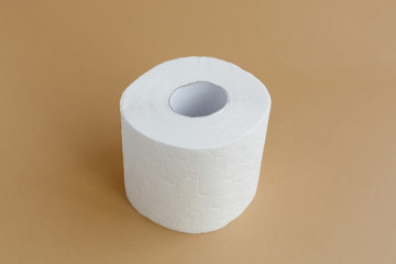 roll of white toilet paper on a brown background