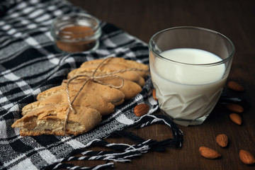 Homemade Italian cookies cantuccini on checkered napkin and glass of milk