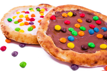 Sweet pizza with marshmallow sauce and colored sweets, chocolate pizza on a white plate