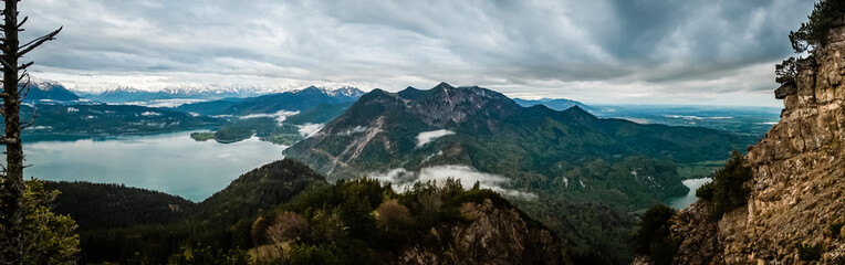 Panorama view over the mountains with clouds and fog and lake